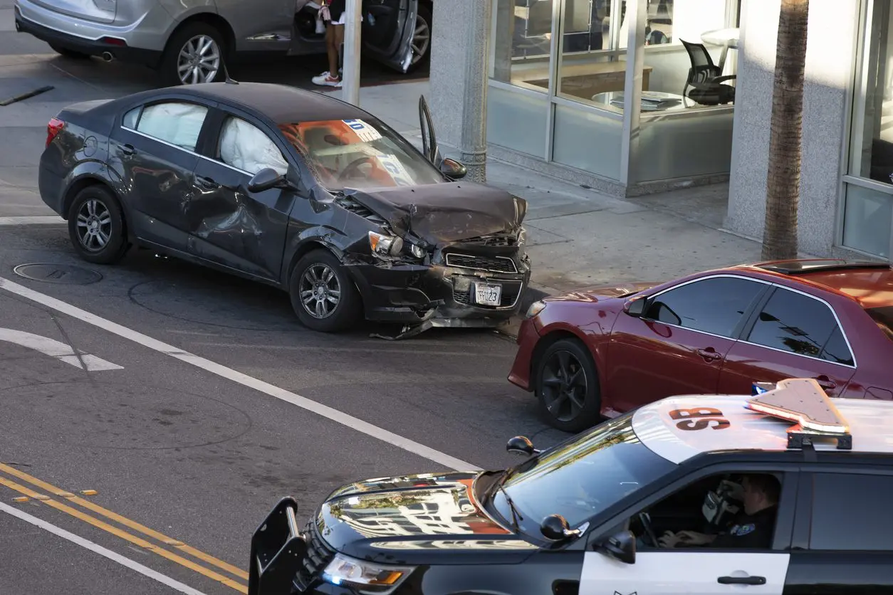 Car accident in road with police car. Our Houston car wreck attorneys fight for those injured by negligent drivers. 