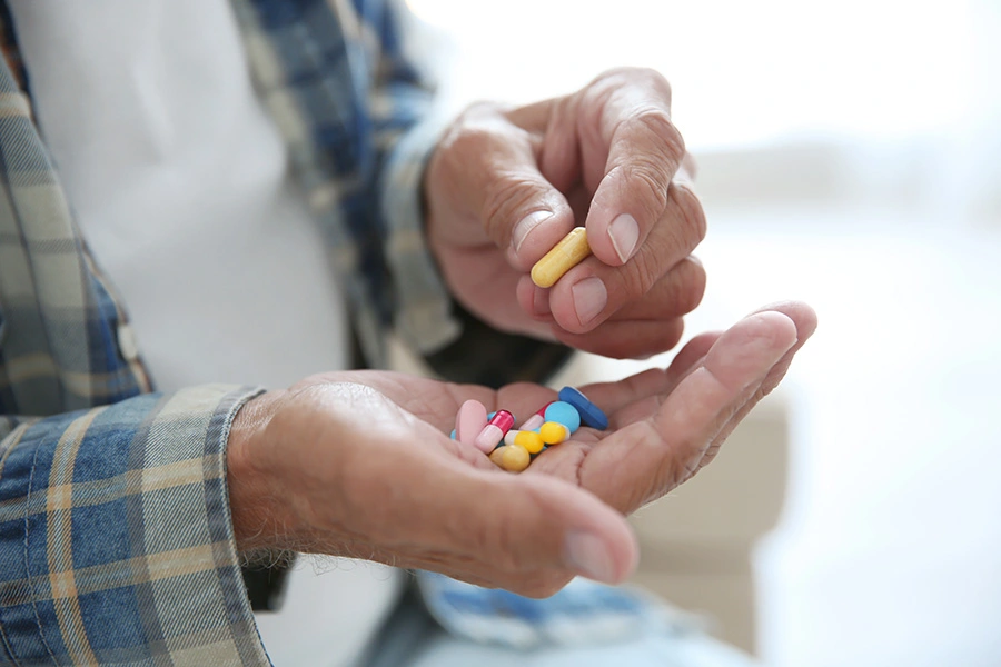 Elderly man taking prescription drugs