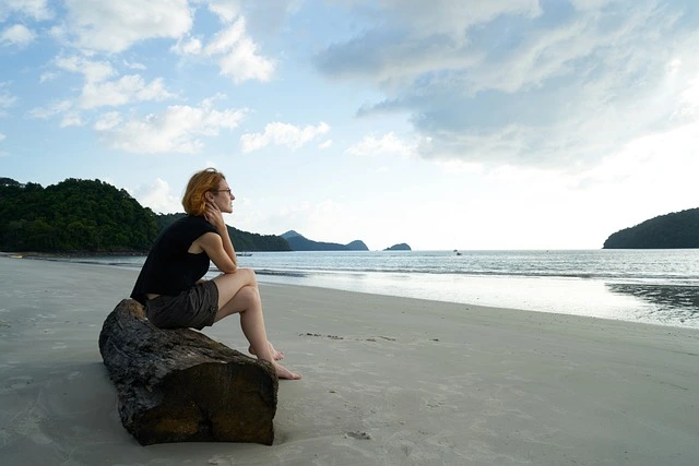 Sad woman sitting on beach.