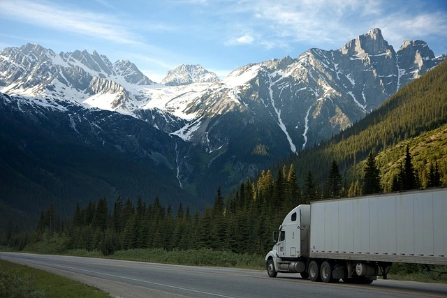 Commercial truck driving through snowy mountains. 